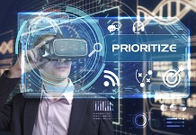 Business, Technology, Internet and network concept. Young businessman working in virtual reality glasses sees the inscription: prioritize